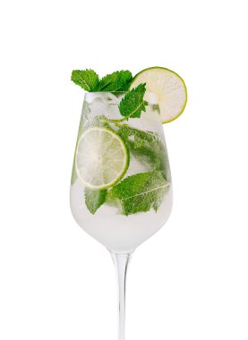 Bir bardak mojito kokteyli kireç ve nane yapraklarıyla beyaz arka planda duruyor.