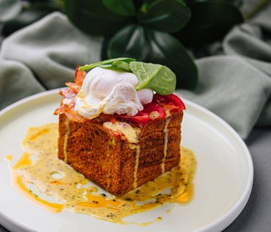 Haşlanmış yumurta ve brioche küpünde Hollandaise soslu Benedict yumurtasının modern kıvrımı.