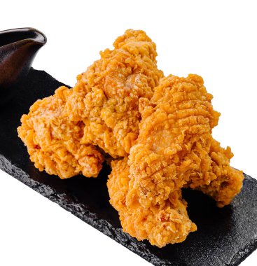 Çıtır çıtır kızarmış tavuk kanatları siyah bir tepside keyfini çıkarmaya hazır.