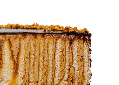 Çikolata ve fındıkla kaplı lezzetli pasta katmanları beyaz arka planda dokusunu gösteriyor.