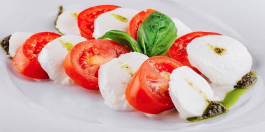 Caprese salatası, tuzlu ve zeytinyağlı taze mozarella, domates ve fesleğenden oluşan klasik bir İtalyan aperatiftir.