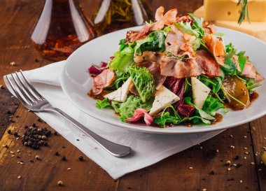 Jamonlu taze salata, armut ve lacivert peynirli. Beyaz tabakta servis edilen yağ ve şifalı otlar soslu.