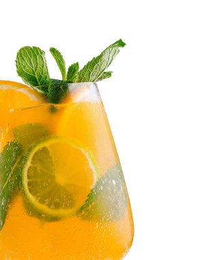 Limon dilimleri, buz küpleri ve taze nane yapraklı bir bardak taze portakal kokteyli.