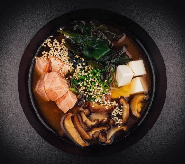 Somon, tofu ve mantarlı, susam tohumlarıyla süslenmiş sıcak ve lezzetli miso çorbasının tadını çıkarın.