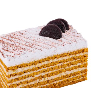 Ağız sulandıran ballı kek, beyaz arka planda izole edilmiş çikolata ve kakao tozuyla süslenir.