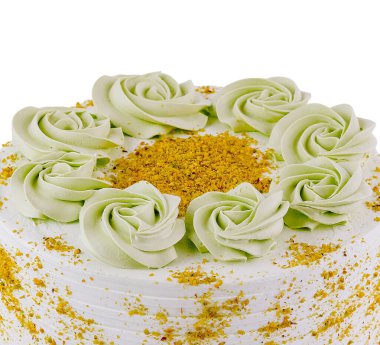 Lezzetli şam fıstıklı pasta tereyağı kremalı çiçeklerle süslenir ve ezilmiş fıstıkla süslenir.