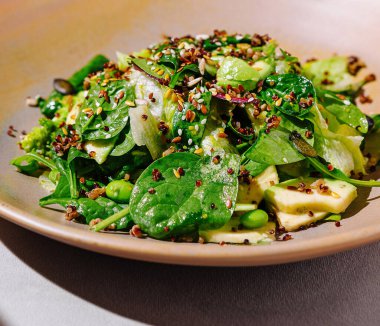 Tahta arka planda kinoa ve avokado ile taze vejetaryen yemek kasesi.