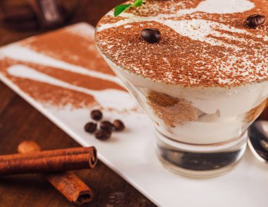 Delicious tiramisu dessert is presented on a white plate, topped with coffee beans and ready to be enjoyed clipart