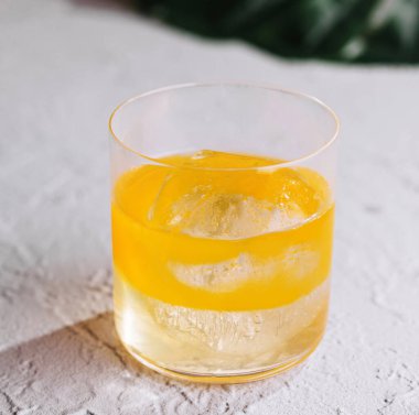 Sarı karışımı canlandırmak, tropikal yapraklarla beyaz desenli arka planda durmaktır.