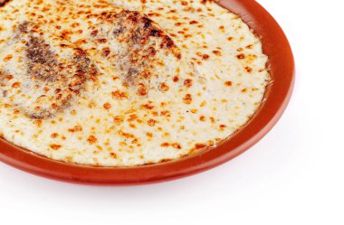 Etli ve peynirli leziz lazanya. Beyaz arka planda izole edilmiş, kırsal bir kil tabakta pişiyor.