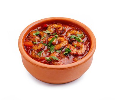 Lezzetli bir karides tabağı, taze biber ve bitkilerden canlı renkler içeren bir çömleğin içinde oturur. Yemek cömertçe, lezzetli bir sosla pişirilir..