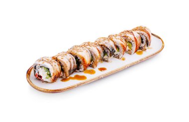 Renkli bir suşi rulosu parlak bir tabakta sergilenir, susam tohumlarıyla cömertçe kaplanır ve bir sos yağmuruyla tamamlanır. Bu canlı yemek pişirmede yaratıcılığı gösteriyor..