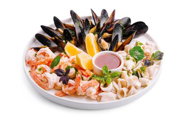 Canlı bir deniz ürünleri tabağında taze karides, midye ve kalamar bulunur. Limon dilimleri ve zengin bir sos ile güzelce düzenlenmiştir. Deniz kenarında yemek yemek için mükemmel..