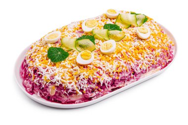 A beautifully arranged layered salad features bright colors with ingredients like boiled eggs, cucumbers, and grated cheese. It is set on a pristine white platter, ideal for celebrations. clipart