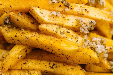 Yakından bakınca mükemmel pişmiş, çıtır çıtır altın patates kızartması görünüyor. Patatesler bol baharatlı otlarla tatlandırılır ve sert tuzla serpiştirilir. Bu da onları cezbedici bir atıştırmalık ya da meze haline getirir..