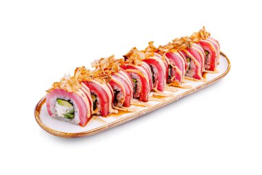 Taze balık dilimleriyle kaplı renkli suşi ruloları, çıtır çıtır çıtır gevreklerle süslenmiş ve sosla süslenmiş, restoran ortamında aşçılık sanatını gözler önüne seriyor..