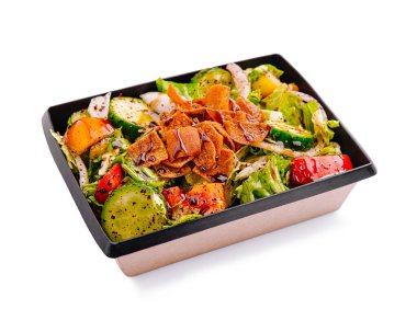 Taze sebzelerle dolu canlı bir salata kasesi. İçinde salata, biber ve salatalık da var. Üstünde de gevrek elementler var..