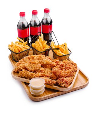 Büyük bir ahşap tepsi gevrek kızarmış tavuk parçaları, altın kızartmalar ve paylaşmak için ideal üç içecek ile doludur..