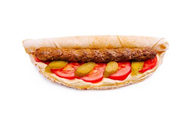 Yumuşak bir tortillaya sarılmış lezzetli bir kebap. Taze domates, turşu ve ilave tat için bir kat kremalı sos ile tamamlanmış. Hızlı bir yemek için mükemmel..