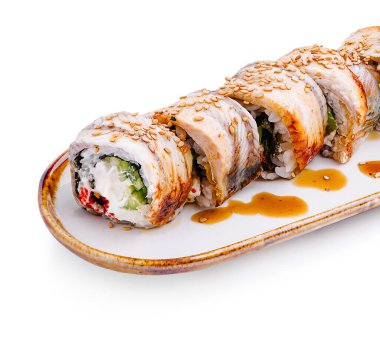 Renkli suşi ruloları zarif beyaz bir tabakta güzelce düzenlenir. Her rulo taze malzemeler içeriyor ve üzerine susam tohumları dökülüyor..