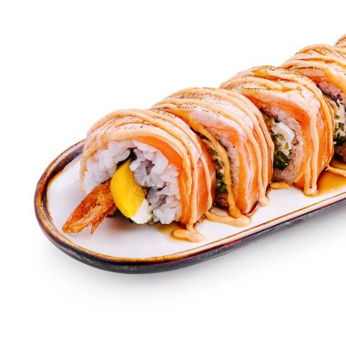 Taze suşi ruloları somon, karides ve avokado katmanları bir tabakta güzelce sıralanmış. Bir tutam sos bu iştah açıcı tabağa tat katar..