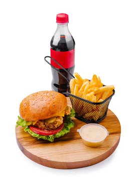 Marul ve domatesli lezzetli bir hamburger sepette kıtır kıtır kızartmaların ve şişede alkolsüz içeceğin yanında oturur. Evde hızlı bir yemek ya da sıradan bir gezinti için idealdir..