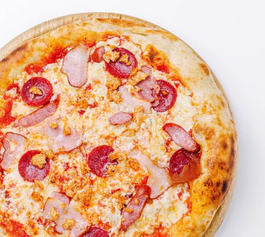 Biberli, jambonlu ve altın hamurlu çıtır çıtır pizzalar ahşap bir tahtanın üzerinde duruyor. Sos ve peynirin canlı renkleri onu iştah açıcı gösteriyor..