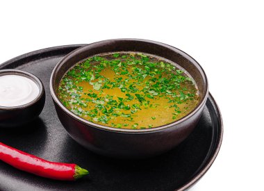 Taze otlarla dolu canlı yeşil bir çorba siyah bir tabakta duruyor. Kırmızı biber ve küçük bir fincan kremalı sos bu davetkar yemeği tamamlıyor. Baharatlı bir lezzet profili sunuyor..