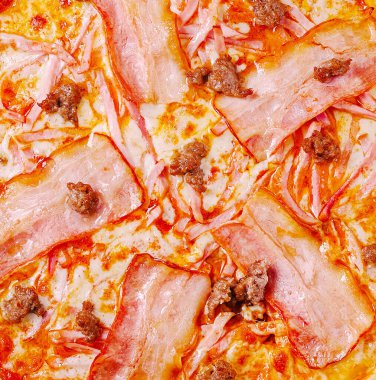 Ağız sulandıran pizza vitrinleri kıtır kıtır domuz pastırması, lezzetli sosis ve erimiş peynirle kaplı altın hamuru her toplantıda paylaşmak için mükemmel bir yemek yaratır..