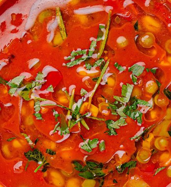 Mısır, biber ve taze otlarla dolu kırmızı bir sebze çorbası serin bir günde tadını çıkarmaya hazır..