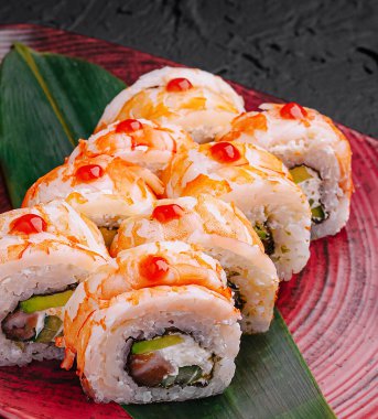 Renkli suşi ruloları titizlikle dekoratif bir tabakta düzenlenir. Her rulo taze malzemeler ve eşsiz malzemeler içeriyor. Mutfak becerileri ve yaratıcılığı gözler önüne seriliyor..