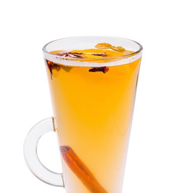 A tall glass cup filled with a warm, fragrant beverage featuring spices and herbs. The drink has a golden color, with visible cinnamon and other ingredients floating on top. clipart