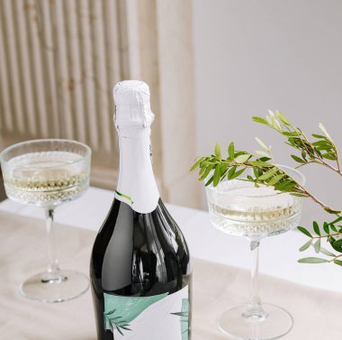 Işıl ışıl şarapla dolu iki kristal bardak güzel bir sehpanın üzerinde şık bir şişenin yanında oturur. Taze yeşillik şenlikli atmosfere biraz zarafet katar..