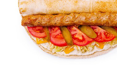 Yumuşak ekmeğin üzerinde ızgara sosis, domates, turşu ve peynir katmanları olan taze yapılmış sandviç. Hızlı bir öğle yemeği veya atıştırmalık için mükemmel..