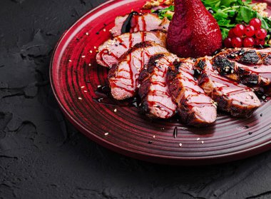 A colorful plate showcases tender grilled duck breast, garnished with a sweet pear, greens, and garnet berries, highlighting an elegant culinary presentation. clipart