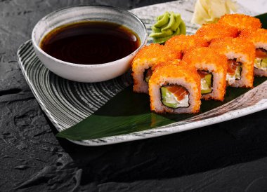 Soya sosu, zencefil ve wasabi ile servis edilen tobiko soslu iştah açıcı California usulü suşi.