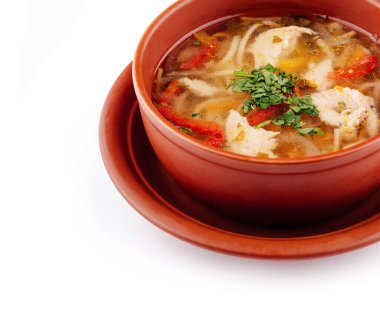 Çamur kasesi taze maydanozla süslenmiş tavuk çorbası ile dolu.