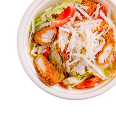 Canlı bir salata kasesinde taze marul, dilimlenmiş domates ve dilimlenmiş peynirle kaplı bir yatakta çıtır tavuk şeritleri yer alır. Günün her saatinde hızlı ve sağlıklı bir yemek için ideal..