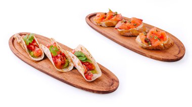 Füme somonla kaplı taze taco ve gevrek bruschetta 'nın tadını çıkar. Zarif ahşap tabaklar üzerinde mükemmel bir şekilde düzenlenmiş, bu yemek, mutfak sanatını gözler önüne seriyor..