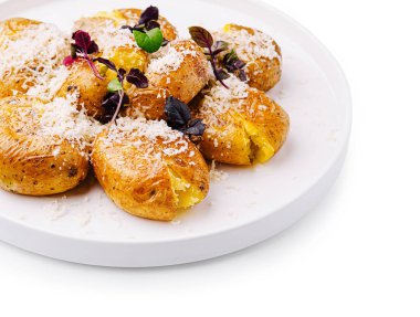 Bir tabak fırında patates peynir ve taze otlarla süslenir. Tabakta sıcak, kabarık iç kısımlar ve gevrek bir dış görünüş var. Rahatlatıcı yiyecekler için yanıp tutuşan insanlara hitap ediyor..