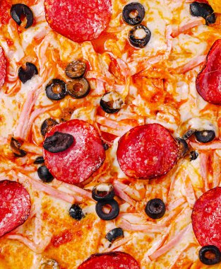 Biberli, siyah zeytinli lezzetli bir pizza ve jambon beğenilmeye hazır. Eriyen peynir, bu davetkar yemeğin lezzetli malzemelerini mükemmel bir şekilde tamamlıyor..