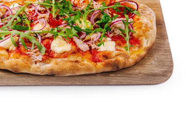 Tahta servis tepsisinde domates, roka, soğan ve peynirli iştah açıcı pizza.