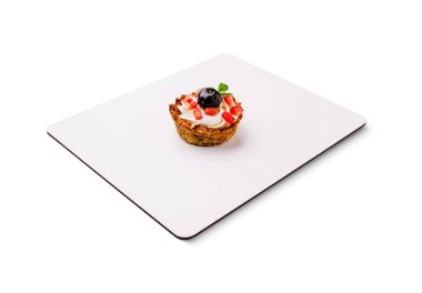 Taze çilek ve yaban mersiniyle kaplı kremalı katmanlarla dolu lezzetli bir tatlı fincanı. Canlı renkler beyaz arka planda göze çarpıyor, tatlı hoşgörüyü davet ediyor..