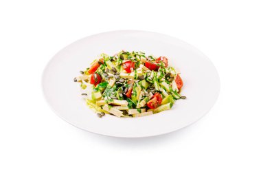 İçinde marul, domates ve kabak tohumlarıyla süslenmiş mevsimlik sebzeler bulunan canlı salata. Gündüz vakti modern bir mutfak ortamında hazırlanmış sağlıklı bir yemek..