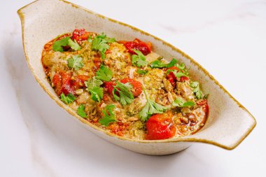 Sulu tavuk taze otlar ve renkli sebzelerle dekoratif bir tabakta servis edilir. Bu davetkar yemek aile toplantıları ya da özel durumlar için mükemmeldir..