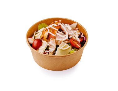 Dilimlenmiş tavuk, marul, vişneli domates ve kremalı sosla dolu bir salata kasesinin detaylı görüntüsü. Bu sağlıklı yemek kahverengi bir karton kutuda sunuluyor..