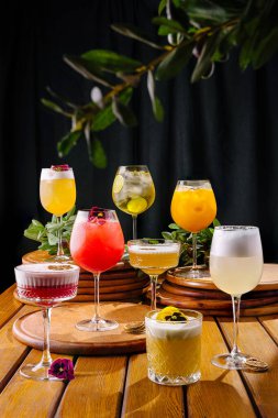 Canlı bir kokteyl seçimi ahşap tahtalarda sergilenir. Her cam eşsiz renkler ve süslemeler sergiliyor. Toplantılar için mükemmel bir ortam yaratıyor..