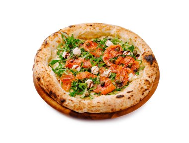 Lezzetli somon, taze roka ve dairesel ahşap bir tabakta sergilenen balzamik sirke serpiştirilmiş taze bir pizza. Sıradan bir yemek için mükemmel..