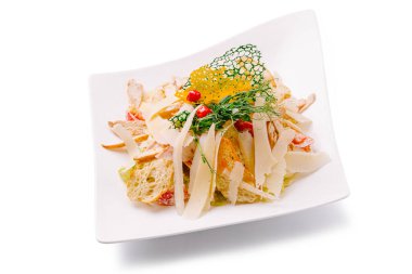 Canlı bir salata dilimlenmiş tavuk, peynir talaşı ve beyaz bir tabakta renkli süslemeler içerir. Taze malzemeler lezzetli bir yemek için birleşir. Öğle veya akşam yemeği için..