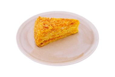 Altın pastanın nefis bir dilimi sade bir tabakta oturur, altında çıtır çıtır bir üst ve nemli katmanlar sergiler. Bu ikram tatlı severler için mükemmeldir ve günün her saatinde keyiflidir..